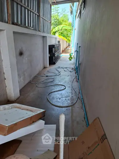 Narrow outdoor corridor with storage potential and garden view