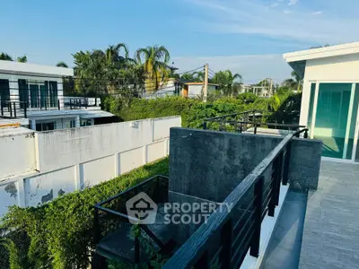 Spacious balcony with modern railing and lush greenery view