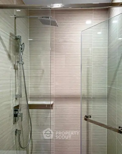 Modern bathroom with sleek glass shower enclosure and rainfall showerhead.