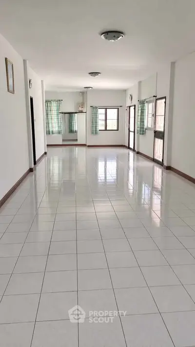 Spacious tiled living area with large windows and natural light, perfect for modern living.