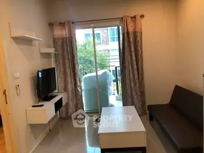 Cozy living room with modern decor and balcony access in urban apartment.