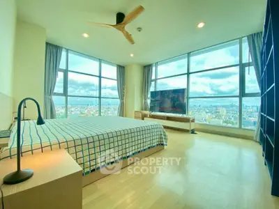 Spacious bedroom with panoramic city views and modern decor