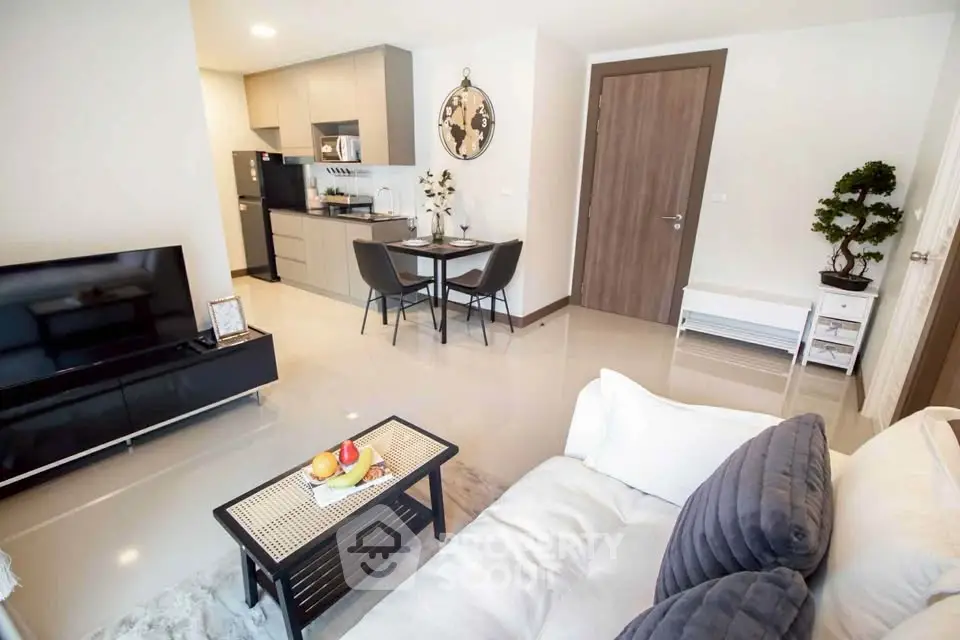Modern living room with open kitchen, sleek furniture, and cozy decor in a stylish apartment.