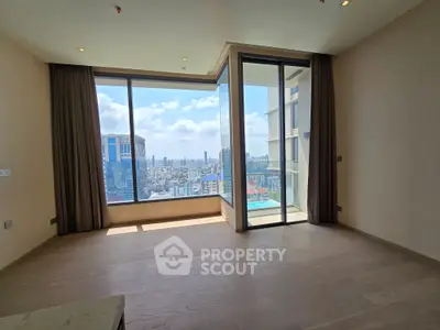 Spacious living room with panoramic city view and large windows in modern apartment.