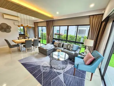 Spacious modern living room with elegant decor and large windows overlooking a lush garden.
