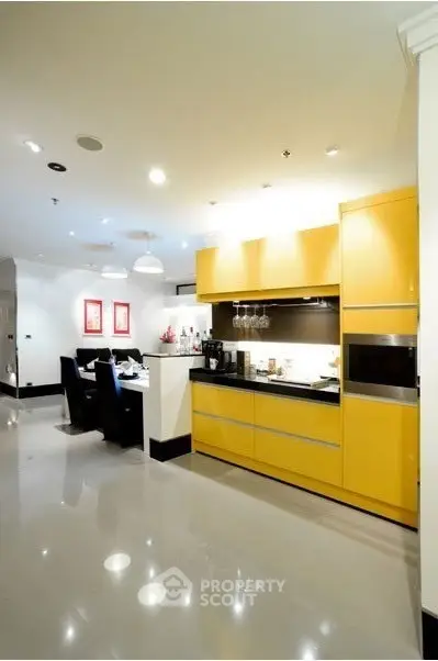 Modern kitchen with vibrant yellow cabinets and sleek dining area
