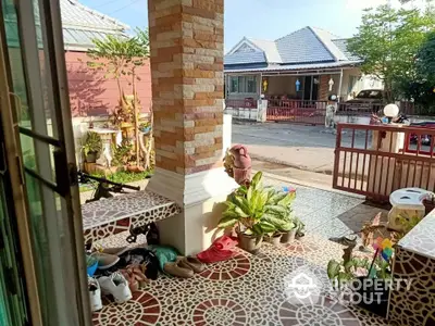 Charming front porch with decorative tiles and lush plants in a suburban neighborhood