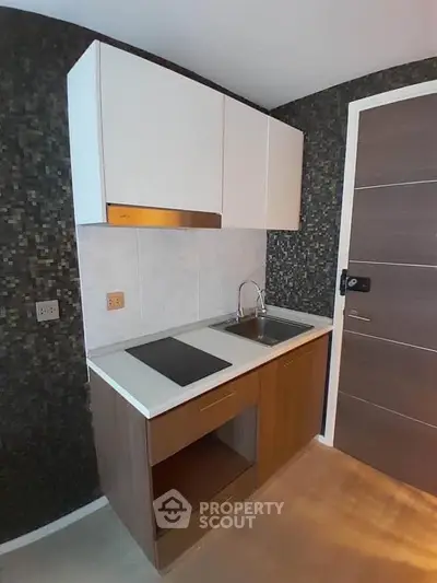 Compact modern kitchen with sleek cabinetry and built-in stovetop