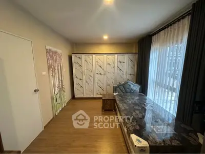 Spacious bedroom with elegant decor and large windows for natural light.