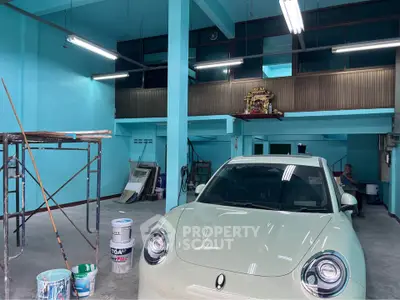 Spacious garage with modern car and vibrant blue walls, ideal for vehicle storage or workshop space.
