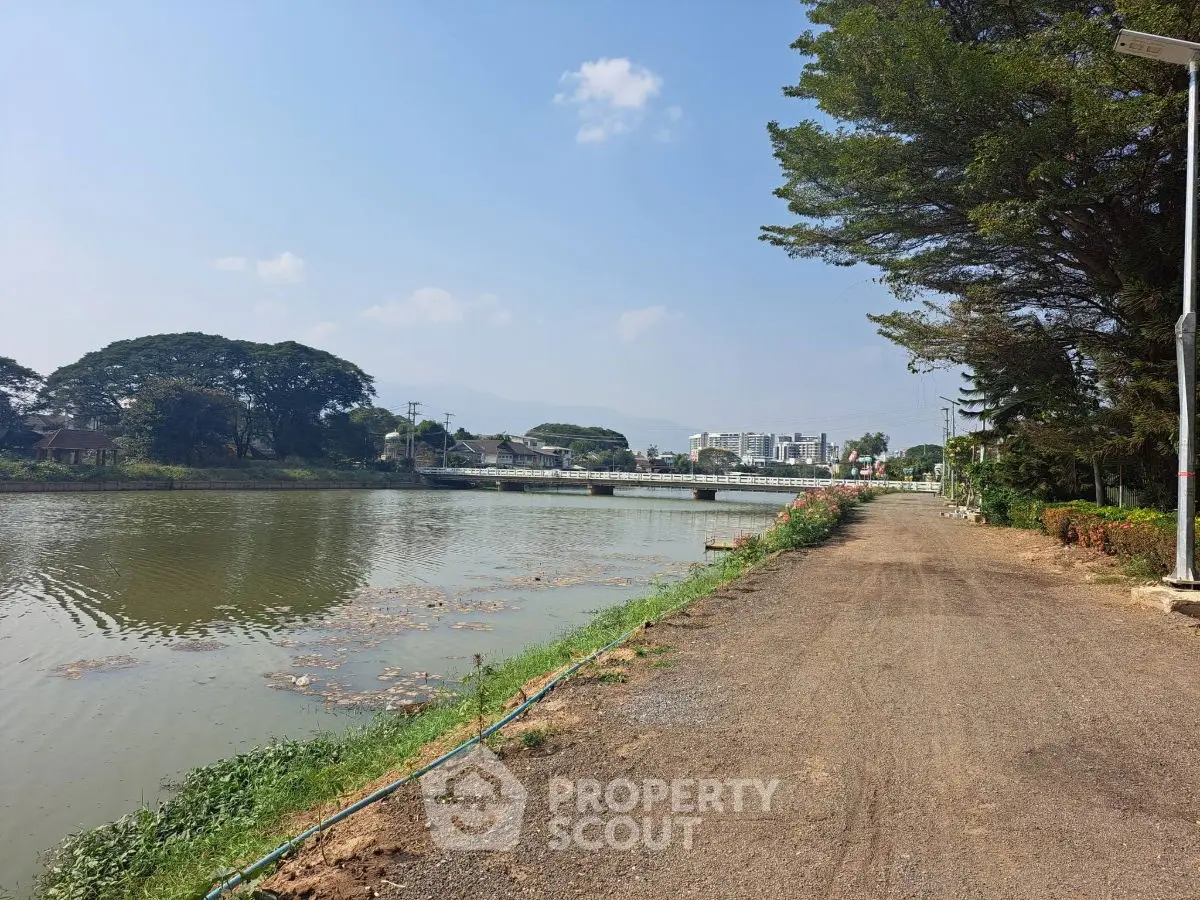 Scenic riverside view with clear skies and distant cityscape, ideal for tranquil living.
