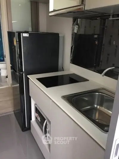 Modern compact kitchen with sleek appliances and efficient layout in a stylish apartment.