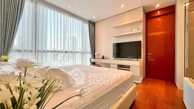 Luxurious bedroom with modern decor and large windows offering city views.