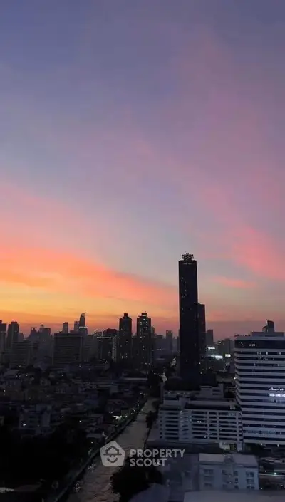 Stunning cityscape view at sunset with high-rise buildings and vibrant sky colors.