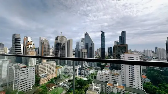 Stunning city skyline view from a modern balcony with glass railing.
