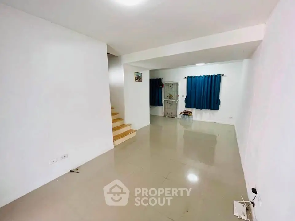 Spacious living room with modern design and staircase, ideal for family gatherings.
