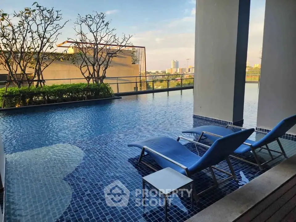 Luxurious rooftop pool with city view and modern lounge chairs, perfect for relaxation and leisure.