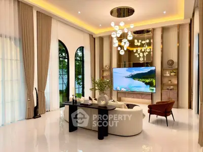 Luxurious living room with high ceilings, elegant chandelier, and large windows offering a serene garden view.