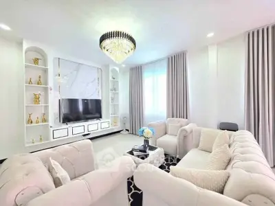 Luxurious living room with elegant chandelier and plush sofas in a modern home.