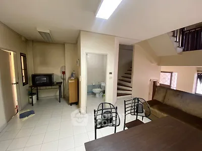 Cozy living area with staircase and compact kitchen setup