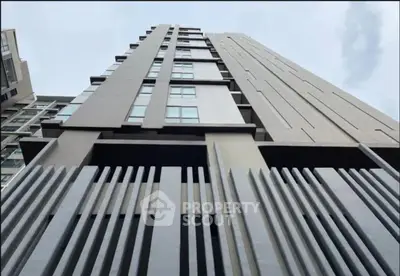 Modern high-rise building with sleek architectural design and large windows.