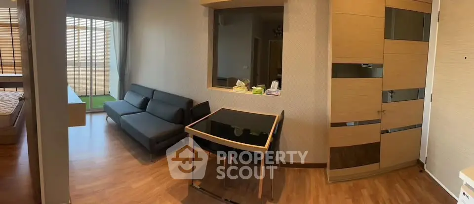 Modern apartment interior with sleek furniture and wooden flooring, featuring a cozy living area and bedroom.