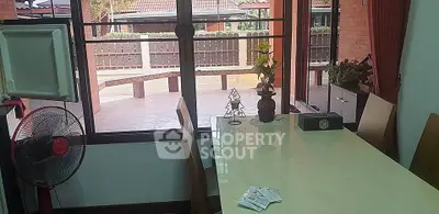 Spacious dining area with large windows overlooking a patio, perfect for family gatherings.