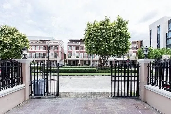 Charming townhouse complex with gated entrance and lush greenery
