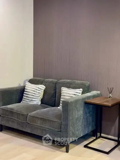 Cozy living room with plush gray sofa and stylish side table, perfect for relaxation.