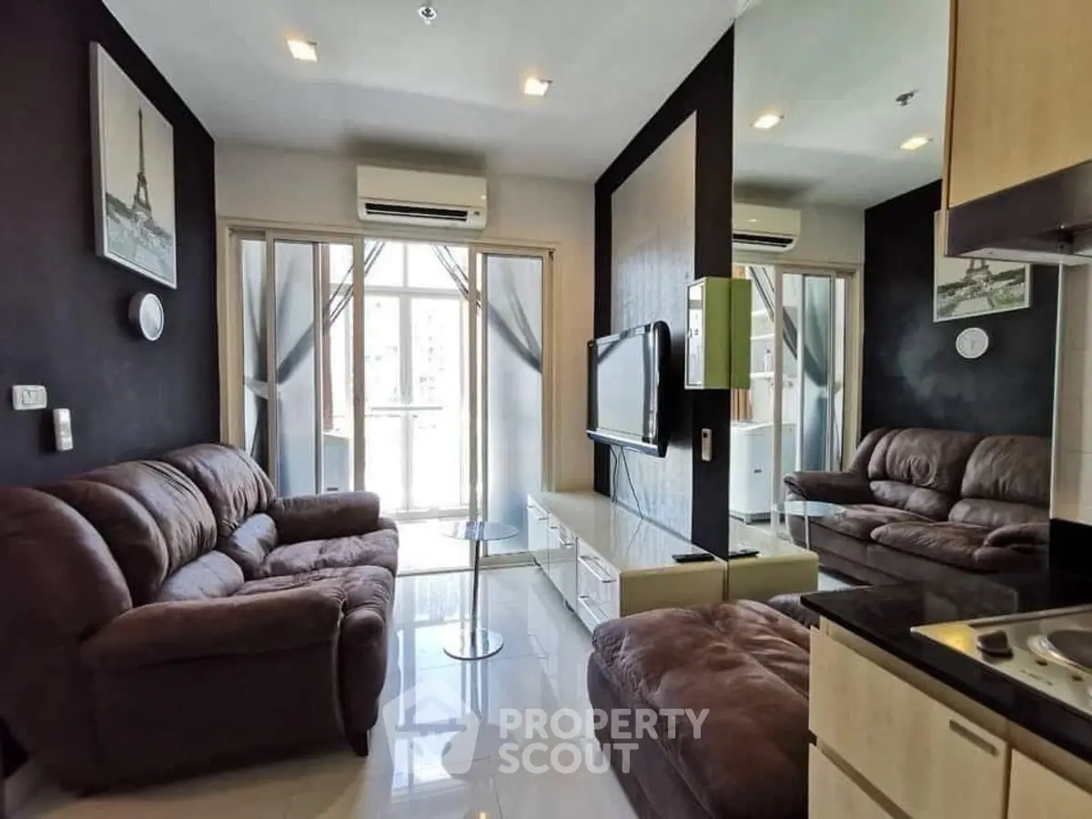 Modern living room with plush sofas and large windows in a stylish apartment.