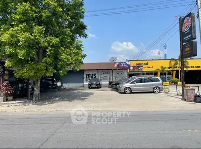 Commercial property with parking space and signage on a sunny day.