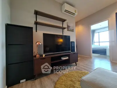 Modern living room with stylish furniture and large TV, showcasing open layout and cozy ambiance.