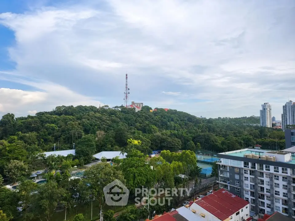 Scenic view of lush greenery and urban skyline from a high-rise building