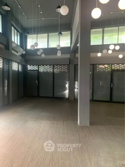 Spacious modern interior with high ceilings and stylish lighting, perfect for versatile use.
