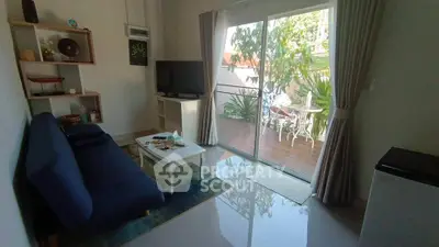 Charming living room with garden view and cozy seating area, perfect for relaxation.