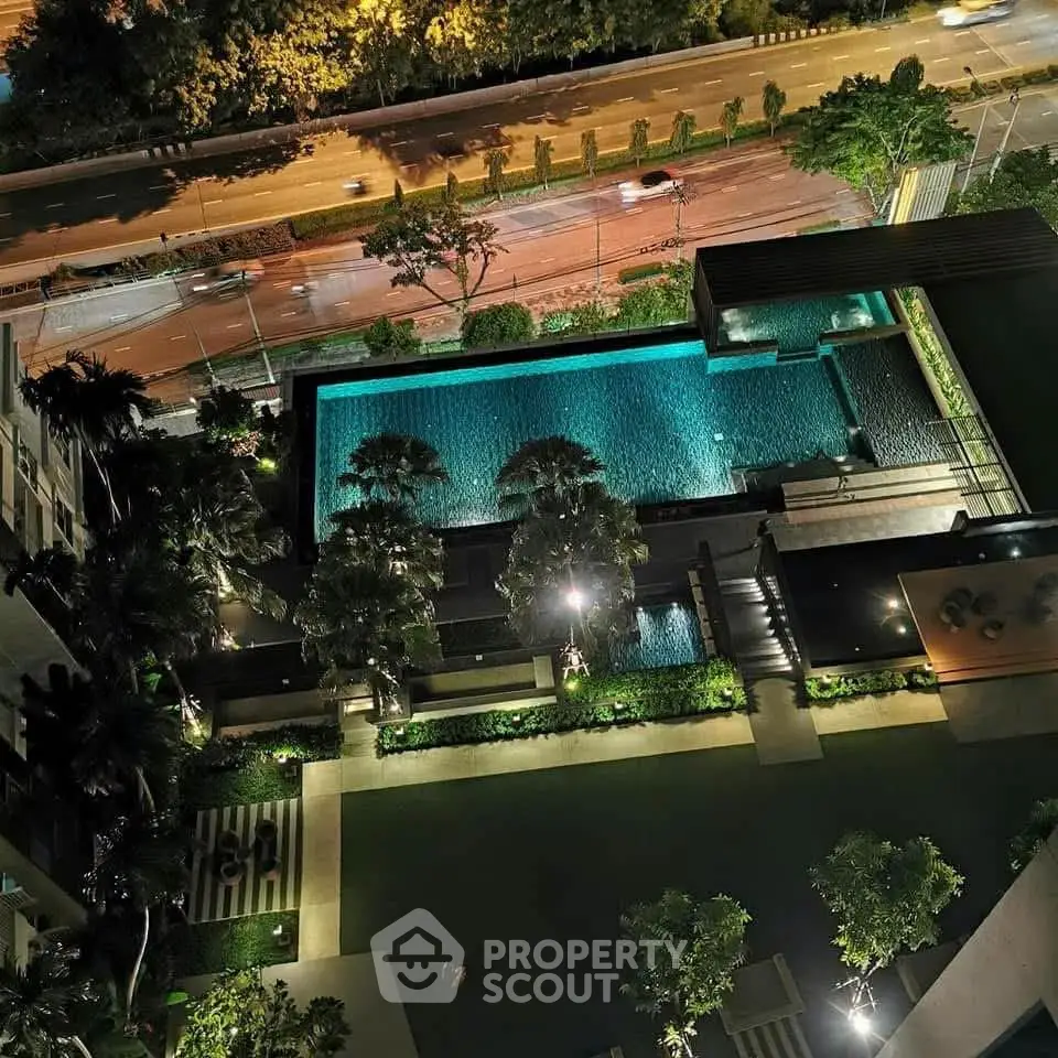 Luxurious rooftop pool with stunning night view in modern residential complex.