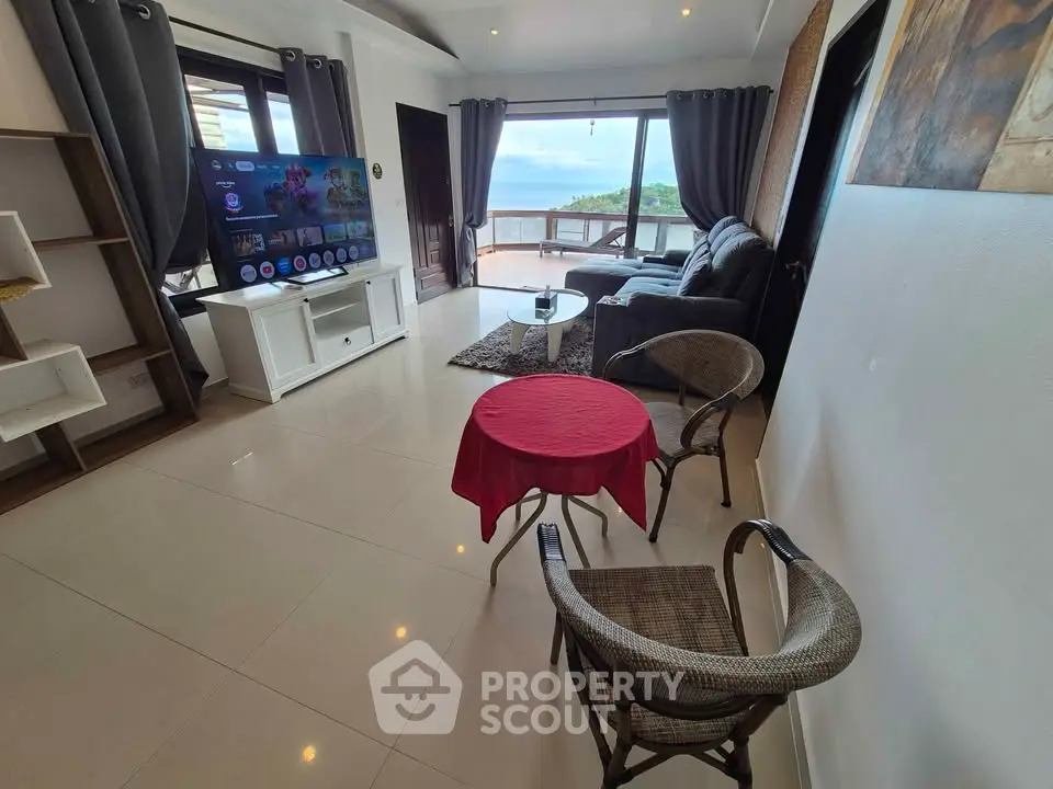 Spacious living room with modern decor and stunning ocean view, perfect for relaxation and entertainment.