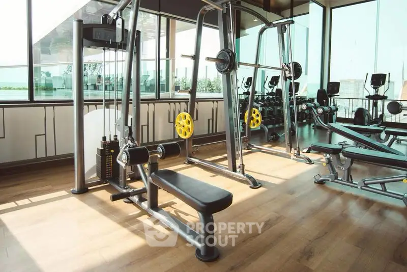 Modern gym with state-of-the-art equipment and panoramic windows offering a scenic view.