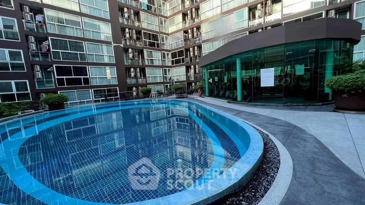 Modern apartment complex with a sleek outdoor pool and glass-walled gym.