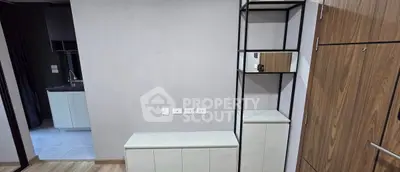 Modern apartment interior with sleek storage and kitchen view