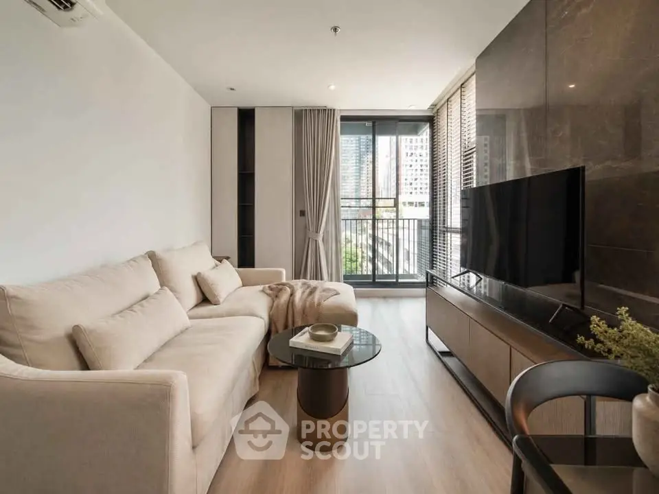 Modern living room with sleek design, large TV, and balcony view in a stylish apartment.