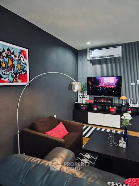 Stylish living room with modern decor and wall-mounted TV, perfect for entertainment.