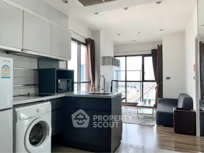 Modern open-plan kitchen and living area with city view, featuring sleek appliances and stylish decor.