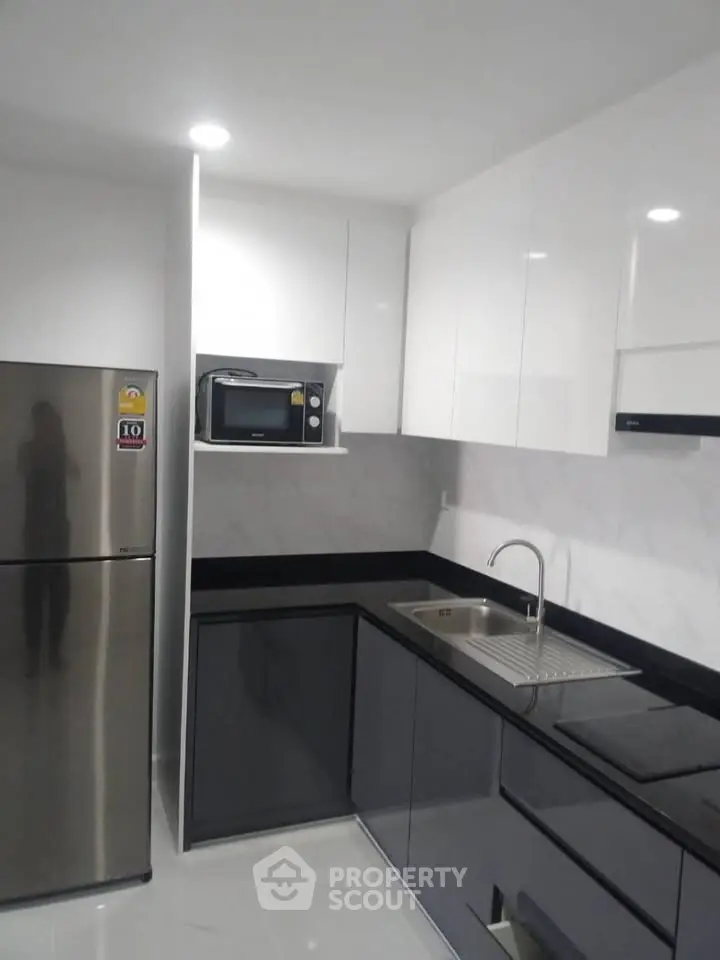 Modern kitchen with sleek cabinets and stainless steel appliances in a contemporary apartment.