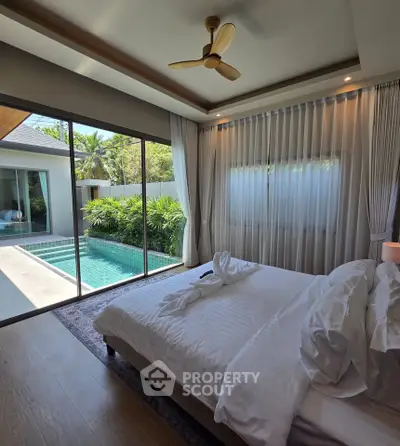 Luxurious bedroom with pool view and elegant decor in a modern villa.