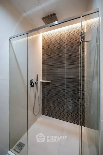 Modern bathroom with sleek glass shower enclosure and stylish tile design.