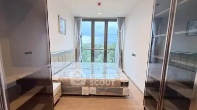 Spacious bedroom with large windows offering scenic views, modern design and ample natural light.
