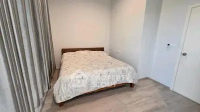 Cozy bedroom with wooden bed frame and floral bedding, perfect for relaxation.