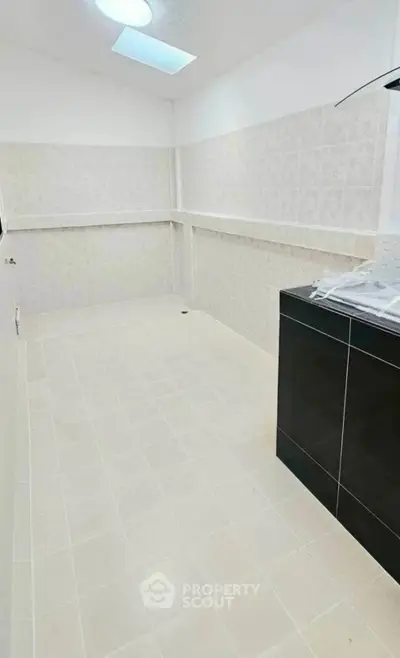 Spacious kitchen with modern black cabinetry and tiled walls, perfect for culinary enthusiasts.