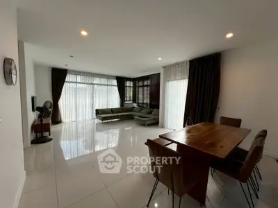 Spacious modern living room with elegant dining area and large windows.